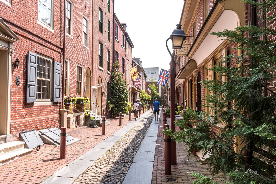 cobblestone Elfreth's Alley in Old City with historic flags